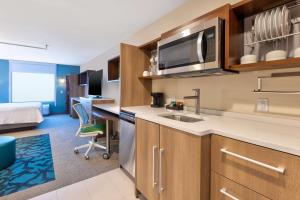 una cucina con lavandino e una scrivania in una stanza di Home2 Suites By Hilton Battle Creek, Mi a Battle Creek