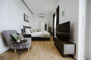a living room with a bed and a flat screen tv at M & N Guesthouse in Volos
