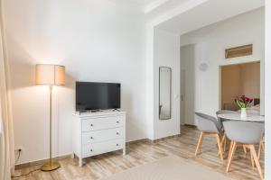 a living room with a table and a tv and a chair at XXXl bed/ free parking/ central in Vienna