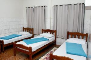 Guajará Palace Hotel في بوتو فيلهو: سريرين في غرفة عليها مناشف زرقاء