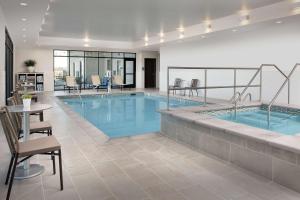 a large swimming pool with a table and chairs at Home2 Suites By Hilton Denver Northfield in Denver