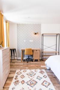 een slaapkamer met een bureau, een bed en een stoel bij **Auberge de l'Aude** in Carcassonne