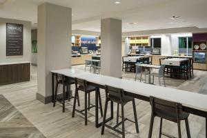 a cafeteria with a long table and chairs at Home2 Suites By Hilton Cape Canaveral Cruise Port in Cape Canaveral