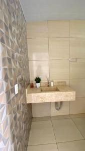 a bathroom with a sink and a tile wall at Recanto das Araras, Transcendental in Bonito