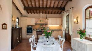 a kitchen with a table with white tables and chairs at Villa Sorripa 6, Emma Villas in Montaione