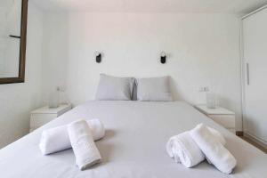 Un dormitorio con una cama blanca con toallas. en Sunset Bungalow, en San Bartolomé 42 fotos más