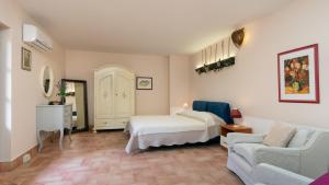 a bedroom with a bed and a couch and a chair at Villa Sorripa 6, Emma Villas in Montaione +23 photos