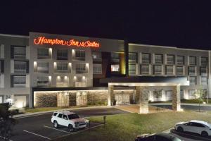 een wit busje geparkeerd op een parkeerplaats voor een gebouw bij Hampton Inn & Suites Charlotte North I 485 in Charlotte