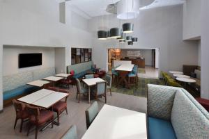 uma sala de jantar com mesas e cadeiras num restaurante em Hampton Inn & Suites Charlotte North I 485 em Charlotte