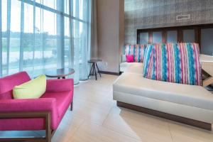 康威Hampton Inn & Suites Conway, Ar的客厅里有一张沙发和两把椅子