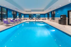 una piscina in un hotel con pareti e sedie blu di Hampton Inn & Suites Conway, Ar a Conway