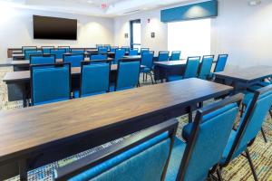 uma sala de aula vazia com mesas e cadeiras azuis em Hampton Inn & Suites Conway, Ar em Conway