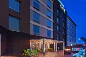 an exterior view of a hotel with tables and chairs at Home2 Suites by Hilton Laredo, TX in Laredo