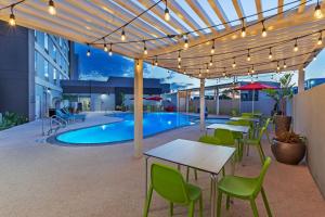 a patio with tables and chairs and a pool at Home2 Suites by Hilton Laredo, TX in Laredo