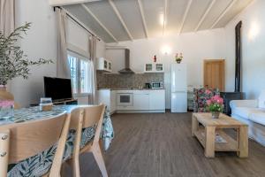 a living room with a dining table and a kitchen at Cortijo La Zahurdilla in Yunquera