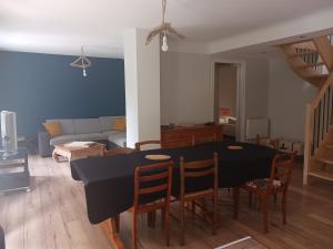 sala de estar con mesa negra y sillas en Loue appartement duplex de 90m2 refait à neuf, en Villefort