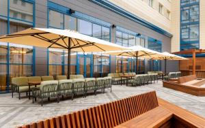 a patio with chairs and umbrellas in a building at Hampton By Hilton Krasnodar in Krasnodar