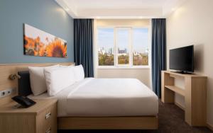- une chambre avec un grand lit blanc et une fenêtre dans l'établissement Hampton By Hilton Krasnodar, à Krasnodar