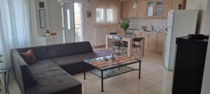 a living room with a couch and a table in a kitchen at Gavrihl home in Kavala