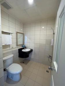 La salle de bains est pourvue de toilettes blanches et d'un lavabo. dans l'établissement 富喜民宿二館, à Nangan