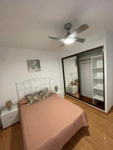 - une chambre avec un lit et un ventilateur de plafond dans l'établissement Apartamento Greenroom Garbinet, à Alicante