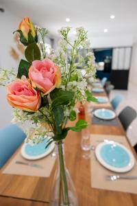a long table with roses in a vase on it at Villa Martinière in Saint-Georges-des-Côteaux +49 photos