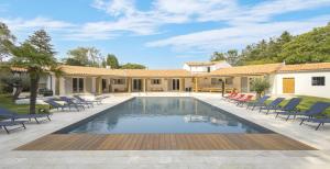 - une piscine avec des chaises et une maison dans l'établissement Villa Martinière, à Saint-Georges-des-Côteaux