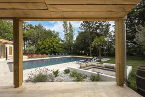 - une piscine dans une cour avec un pavillon dans l'établissement Villa Martinière, à Saint-Georges-des-Côteaux