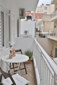 a small balcony with a white table and chairs at Down Town Sitia i in Sitia