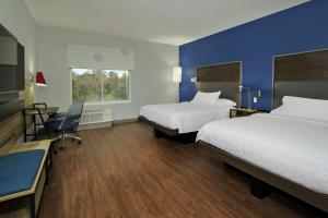 a hotel room with two beds and a blue wall at Tru By Hilton Waco South in Waco