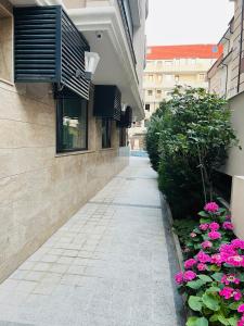 a walkway with flowers on the side of a building at Golden Sea View New in Pomorie