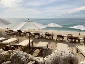 a group of tables and umbrellas on a beach at 4U Resort Samui in Lamai