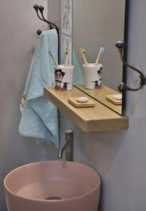 a bathroom with a sink and two cups with toothbrushes at Down Town Sitia i in Sitia