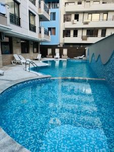 a large swimming pool in front of a building at Golden Sea View New in Pomorie