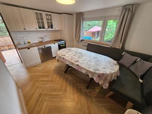 ein Wohnzimmer mit einem Tisch und einer Küche in der Unterkunft Leśne Apartamenty in Hel