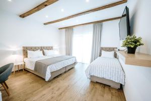 a bedroom with two beds and a large window at Old Town Zagreb Airport in Velika Gorica