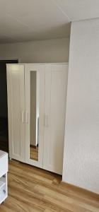 una stanza vuota con armadi bianchi e pavimenti in legno di City Home Zurich a Zurigo