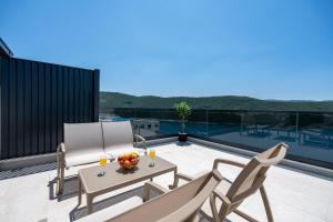 een patio met een tafel en stoelen op een balkon bij Villa Golden in Neum