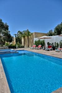 a swimming pool with blue water in a resort at Ta Benna Villa in Għajnsielem