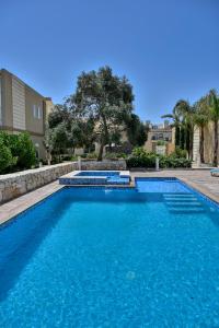 a swimming pool with blue water in a yard at Ta Benna Villa in Għajnsielem