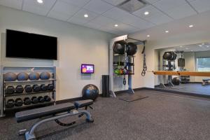 a gym with a bench and a flat screen tv at Tru By Hilton Fort Mill, Sc in Fort Mill