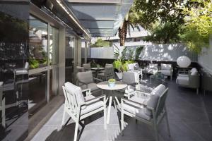 - une terrasse avec une table et des chaises blanches dans un bâtiment dans l'établissement DoubleTree By Hilton A Coruña, à La Corogne