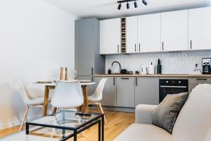 a kitchen and living room with a couch and a table at Witosa View in Krakow