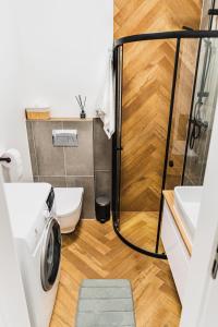 a bathroom with a shower and a washing machine at Witosa View in Kraków