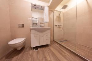 a bathroom with a toilet and a sink and a shower at Aparthotel Mirage Sunset - zona Hotel Rex in Mamaia +7 photos