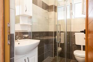 een badkamer met een wastafel, een toilet en een douche bij Apartments Art in Ulcinj