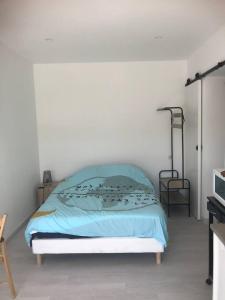 a bedroom with a bed with a blue blanket at studio centre ville avec jardin in Sainte-Maxime