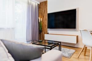 a living room with a tv and a glass table at Witosa View in Kraków