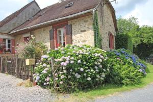 a small stone house with flowers in front of it at Hamlet retreat in Ladignac-le-Long