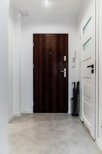 a wooden door in a white room with an entrance at Witosa View in Kraków
